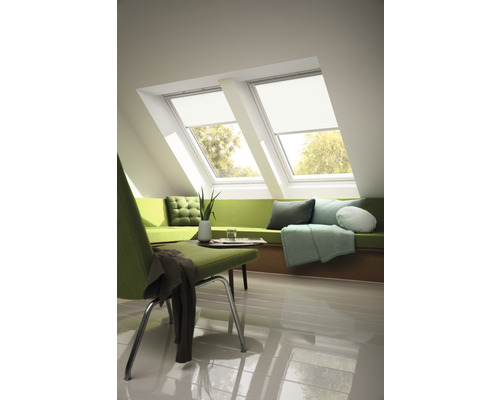 Světlá podkrovní místnost se dvěma střešními okny, zatemňovacími roletami, posezením a židlí
