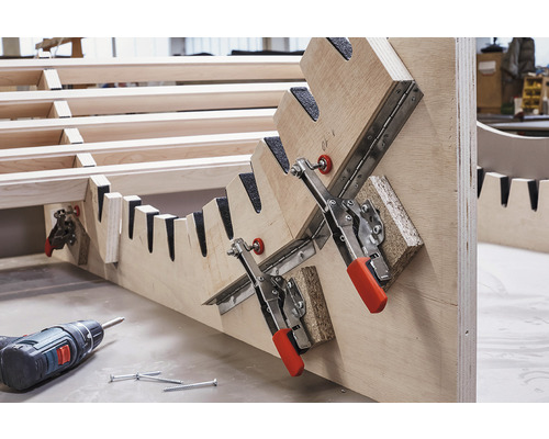 Dřevěná konstrukce s pákovými svorkami, šrouby a akumulátorovým šroubovákem