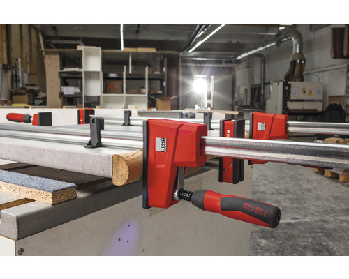 Dílenská scéna s několika lištovými svorkami BESSEY upevňujícími obrobky