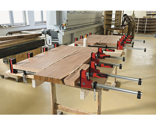 Dřevěné panely jsou stlačeny šroubovými svorkami.