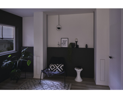 Obývací pokoj s křeslem, odkládacím stolkem, pokojovou rostlinou a dekorací