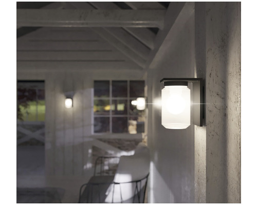 Nástěnné svítidlo z kovu a skla na stěně domu