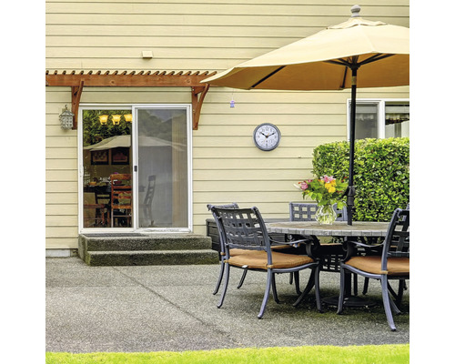 Terasa se stolem, židlemi, slunečníkem a hodinami na zdi