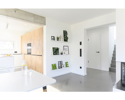 Světlý pokoj s kuchyní, policemi a jídelním stolem