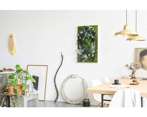 Světlý obývací pokoj s mechovým obrazem, rostlinami a dekoracemi