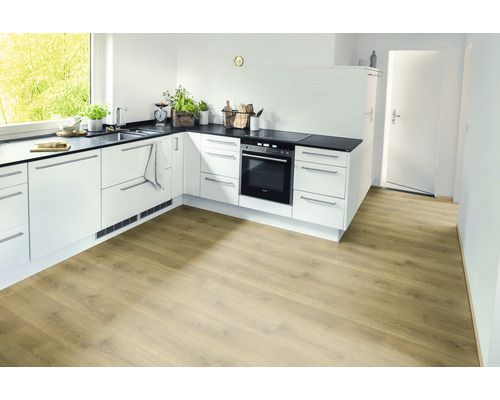 Světlá kuchyně s laminátovou podlahou se vzhledem dřeva, bílými skříňkami a černou pracovní deskou.