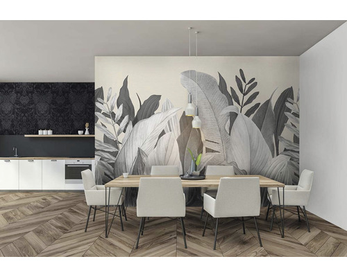 Světlá jídelna s jídelním stolem, židlemi a kuchyňským koutem před nástěnnou tapetou s rostlinnými motivy