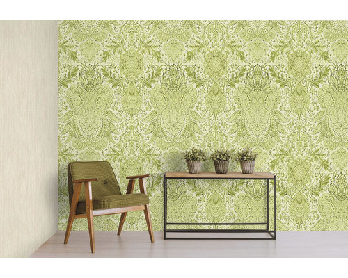 Dekorativní pokoj se stěnou s tapetou se vzorem, křeslem a stolem s rostlinami.