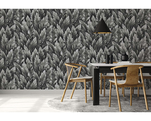 Pohled do místnosti s tapetou se vzorem listů, jídelním stolem a židlemi