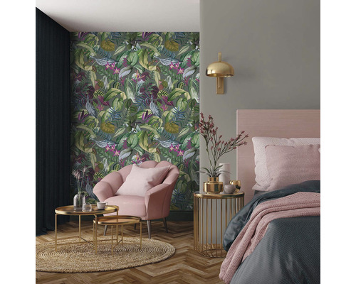 Dekorativní ložnice s tapetou s motivem džungle, křeslem a nočním stolkem
