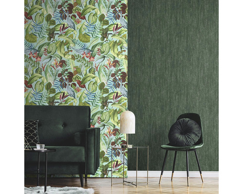 Obývací pokoj se zelenou tapetou se vzorem listů a jednobarevnou zelenou tapetou