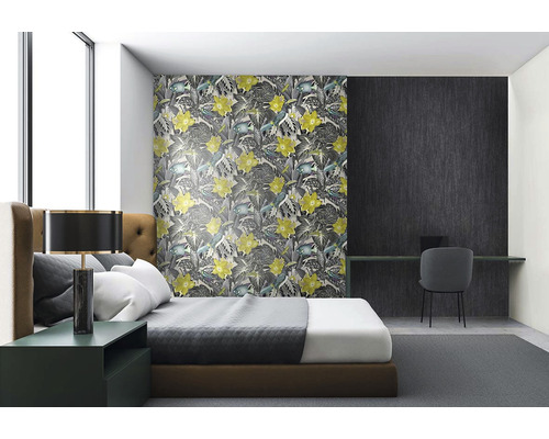 Ložnice s květinovou tapetou, postelí a psacím stolem.