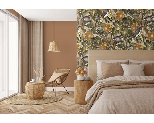 Příjemná ložnice s tapetou s motivem džungle, dřevěnou postelí a ratanovým nábytkem pro přírodní atmosféru.