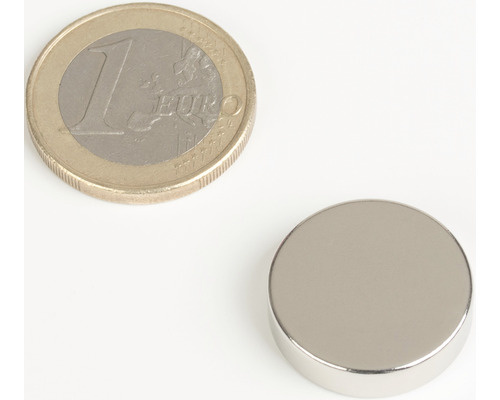 Kulatý magnet vedle jednoeurové mince pro porovnání velikosti