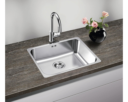 Dřez s baterií a odtokem na kuchyňské lince s vázou květin