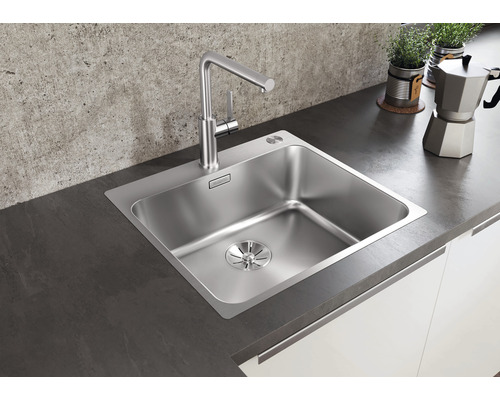 Nerezový dřez s vodovodní baterií v moderní kuchyni.