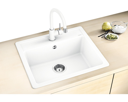 Dřez s vodovodní baterií ve světlé kuchyni