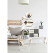 Obývací pokoj s pohovkou, stolem, komodou a šestiúhelníkovou nástěnnou dekorací s motivy krajiny