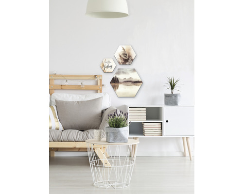 Obývací pokoj s pohovkou, stolem, komodou a šestiúhelníkovou nástěnnou dekorací s motivy krajiny