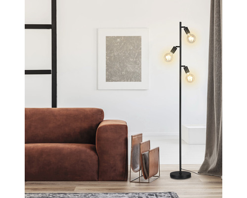 Obývací pokoj se stojací lampou, pohovkou a stojanem na časopisy