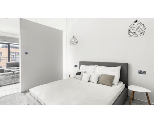 Světlá ložnice s postelí, nočními stolky a geometrickými lampami