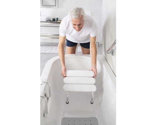 Muž vkládá sedátko do vany pro větší pohodlí a bezpečnost