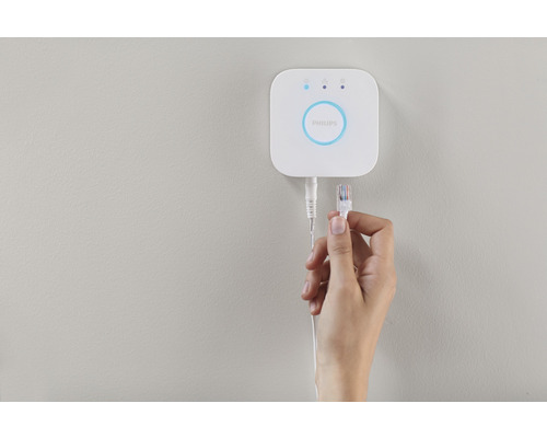 Philips Hue Bridge se síťovým kabelem v ruce