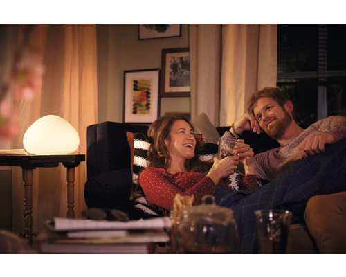 Pár relaxuje v obývacím pokoji s dekorativní stolní lampou