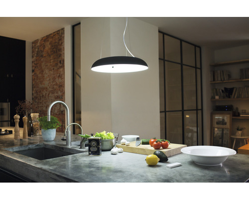 Moderní kuchyně s dřezem, baterií, závěsným svítidlem a ingrediencemi na pracovní desce