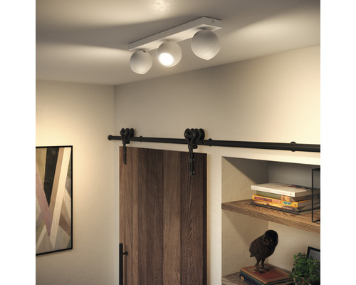 Stropní svítidlo se třemi kulovými lampami ve světlé místnosti s posuvnými dveřmi