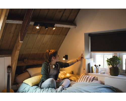 Mládežnický pokoj s šikmou střechou, postelí, oknem s roletou, kytarou a osvětlením