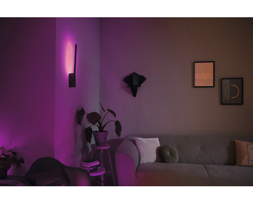 Obývací pokoj s pohovkou, nástěnnou lampou a dekorací