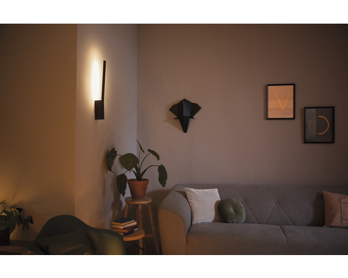 Obývací pokoj s pohovkou, nástěnnou lampou a dekoracemi