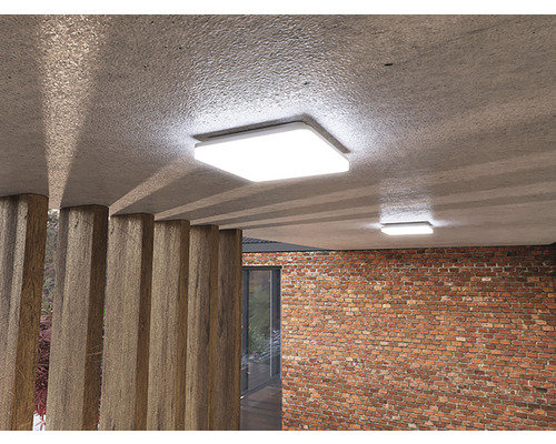 Dvě čtvercová stropní svítidla v místnosti s betonovými a cihlovými stěnami