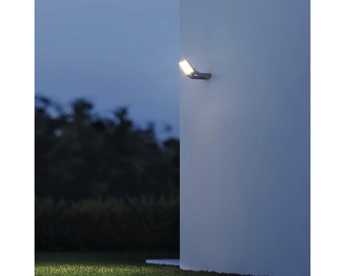 LED venkovní reflektor namontovaný na stěnu se světelným kuželem v zahradě