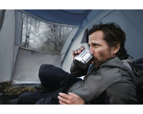 Muž pije z hrnku ve stanu