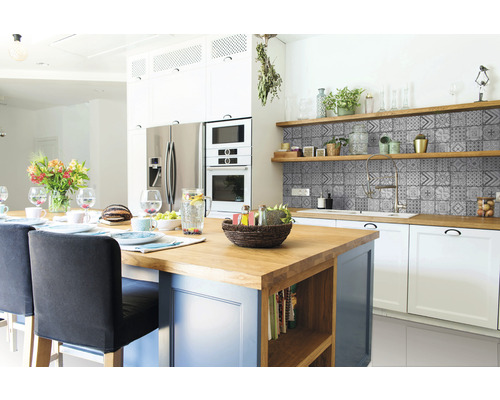 Světlá kuchyně s kuchyňským ostrůvkem, obkládanou stěnou a policemi.