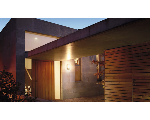Venkovní pohled na moderní dům s dveřmi a venkovním světlem.