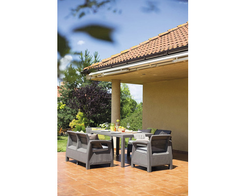 Terasa se zahradním nábytkem sestávajícím ze stolu, křesel a pohovky.