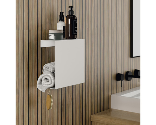 Koupelna se světlou dřevěnou stěnou, bílá nástěnná police s ručníky a kosmetikou.