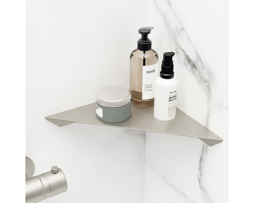 Kovová rohová police v koupelně s kosmetickými produkty