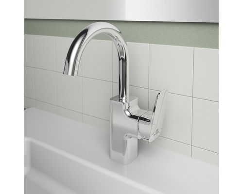 Chromová umyvadlová baterie před bílým obkladem