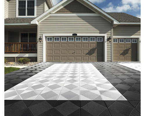 Příjezdová cesta s garážemi a vzorem podlahových dlaždic.