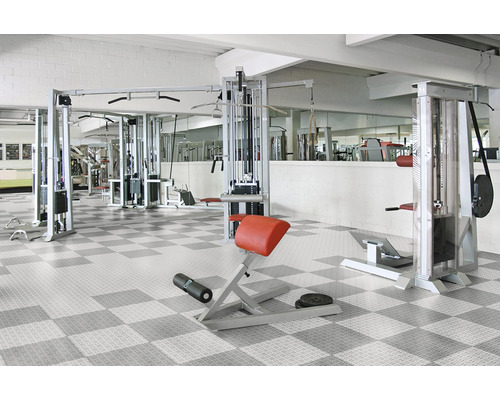 Posilovna s fitness vybavením a šachovnicovou podlahou