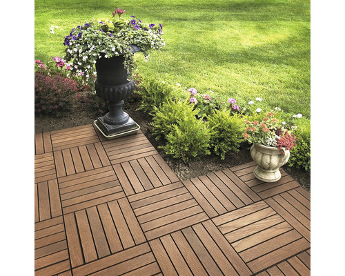 Položené terasové dlaždice v zahradě s květinami v květináčích.