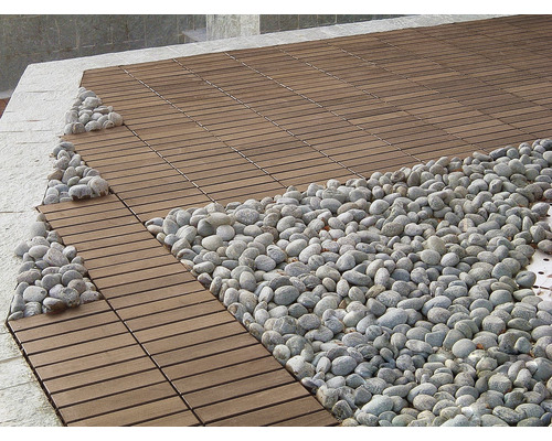 Dřevěná terasa s okrasnými oblázky v zahradě