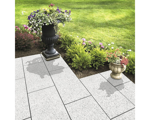 Zahradní chodník s dlažebními kostkami a osázenými květináči