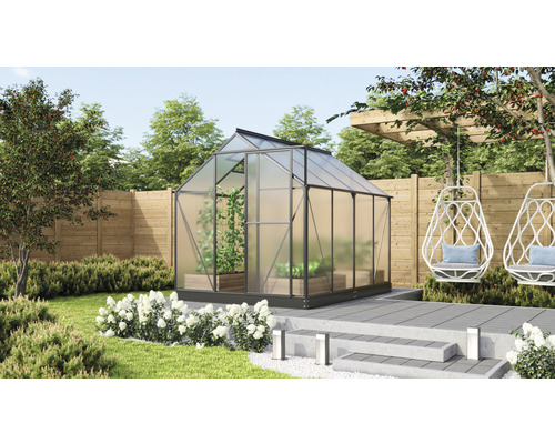 Skleník v zahradě s rostlinami a posezením