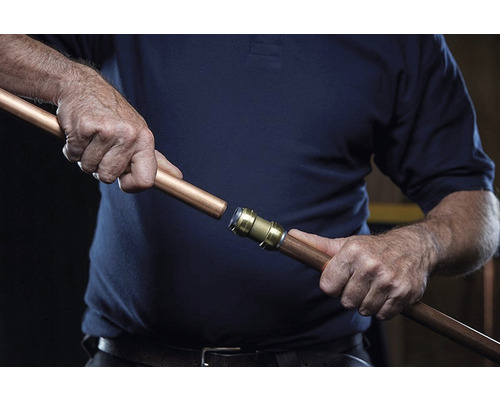 Instalace měděné trubkové spojky osobou