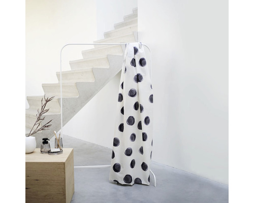 Záclona s puntíkovým vzorem na věšáku na oblečení vedle schodiště
